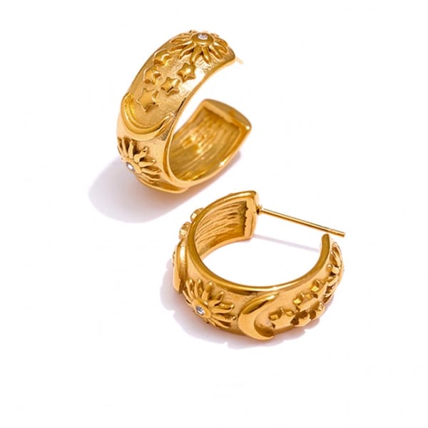 A pair of gold hoop earrings with intricate floral cutout detailing and small clear stone accents, displayed on a clean white background.