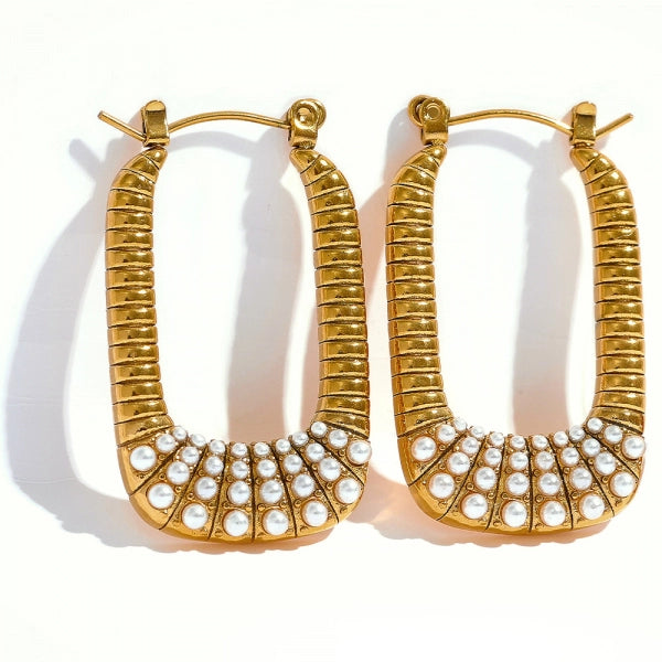 A pair of gold-tone hoop earrings with a textured, ribbed finish and a curved row of small white faux pearls at the bottom, displayed on a clean white background.